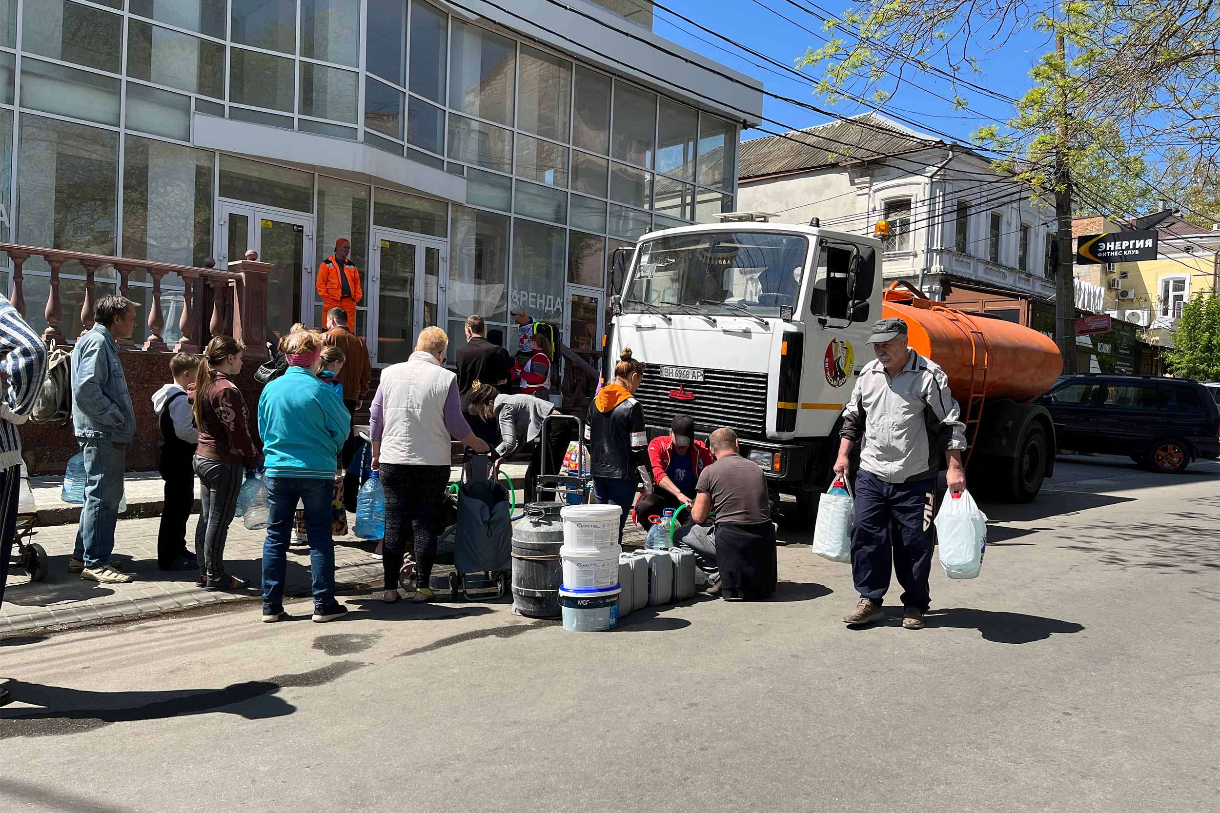 People wait in a line to fill their water container since the city has been without running water for a month now. © IWPR