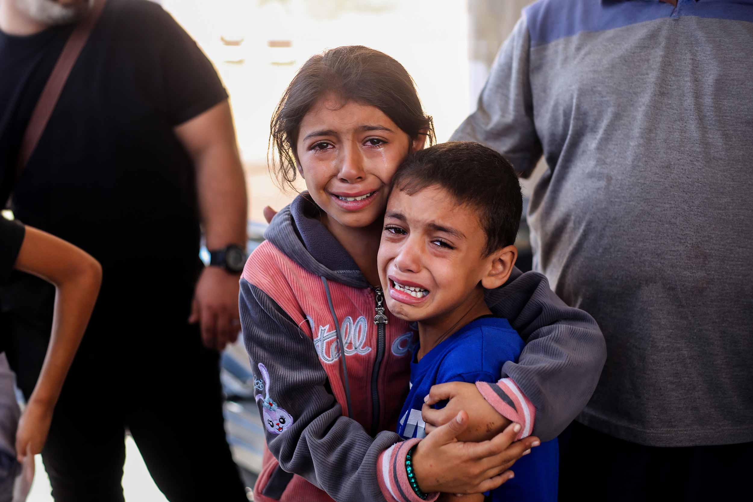 Children crying because of Israeli air raids on October 15, 2023 in Khan Yunis, Gaza. Many Gazan citizens have fled to the south following warnings from the Israeli government to do so. © Ahmad Hasaballah/Getty Images