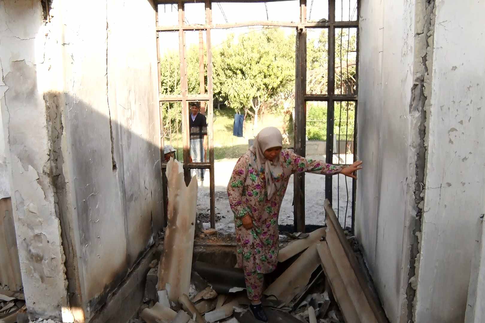 Gulnara Isiralieva walks over the ruins of her destroyed house in Arka, a village in Kyrgyzstan’s Leilek district. She built it with her husband over 20 years with the money he sent from Russia, where he still works. “It all started on Friday morning. We were out in the field for the harvest, when I got a text message that the war had begun,” Gulnara Isiralieva told IWPR. “The children and I rushed into the house, and suddenly explosions and shooting began. We could not start the car and we had to run to reach a safe place. The kids cried, they were terrified.” © IWPR Central Asia