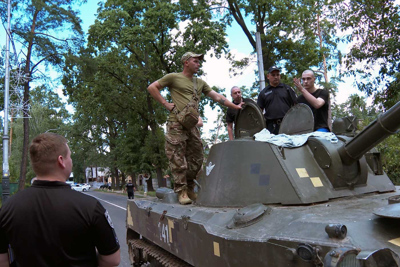 Nikolai Kartashev, accused of killing an unarmed supermarket guard, in the village of Bucha, where the crime happened, with police investigators in August 2023, during the pre-trial investigation. © Ministry of Internal Affairs of Ukraine